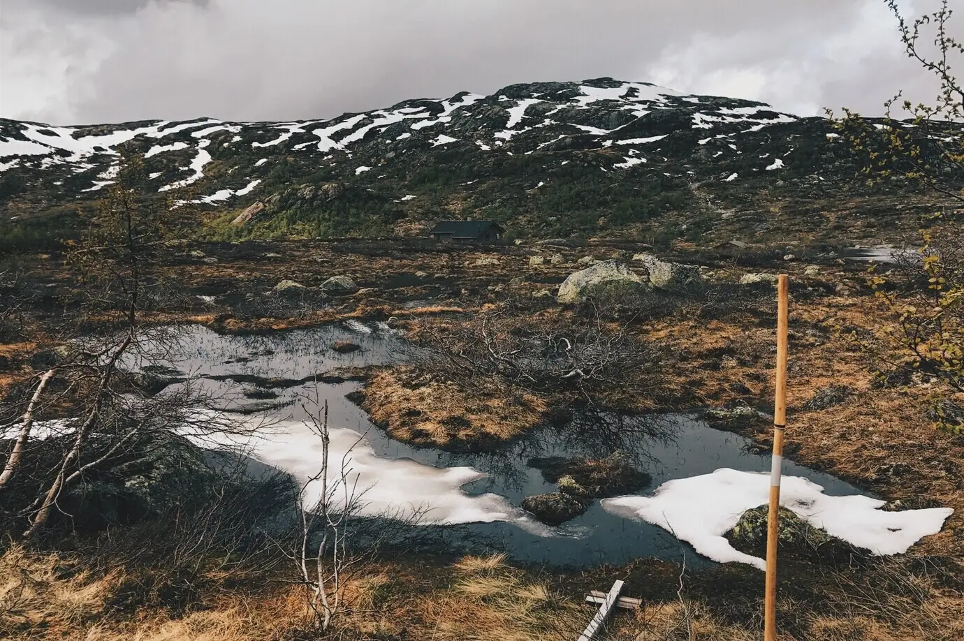 Thick clouds hang over the snow-covered mountains.